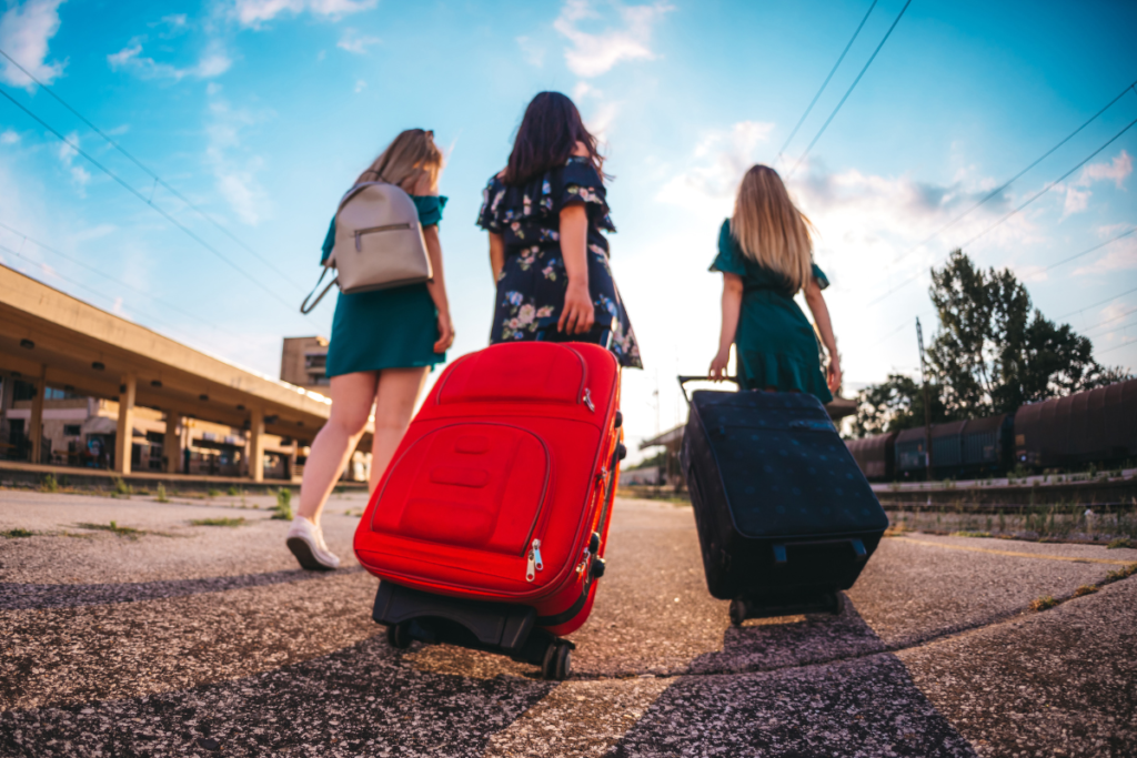 3 friends walking with suitcases on holiday